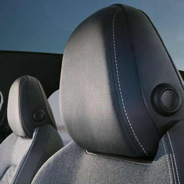 Close-up of car seat headrests against a blue sky background.