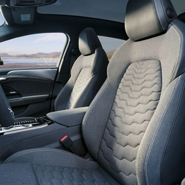Interior of a car showing two front seats with grey upholstery and stylish design.