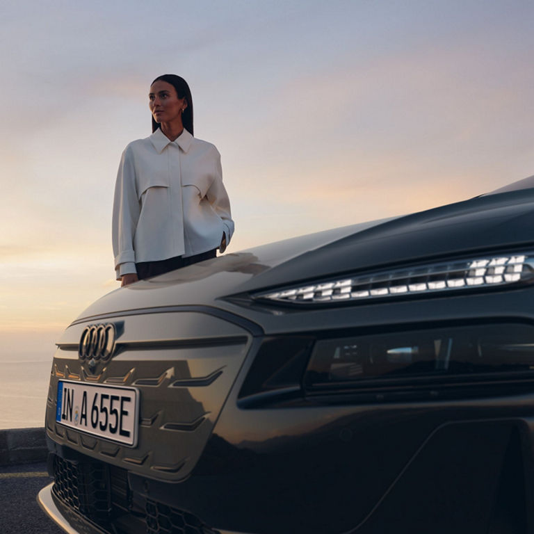 Close-up of Audi's front section with LED headlights and license plate at dusk.