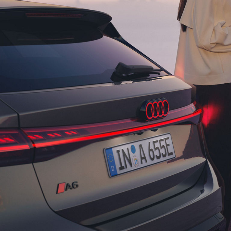 Close-up of an Audi A6 Avant e-tron performance rear with distinctive LED taillights, at dusk.