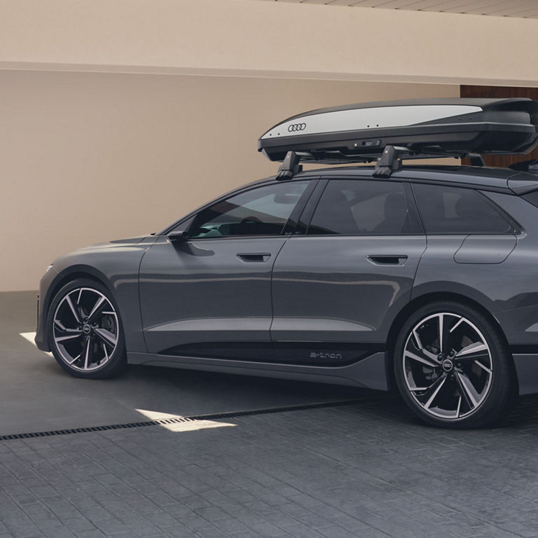 Audi e-tron SUV with roof box parked outside.