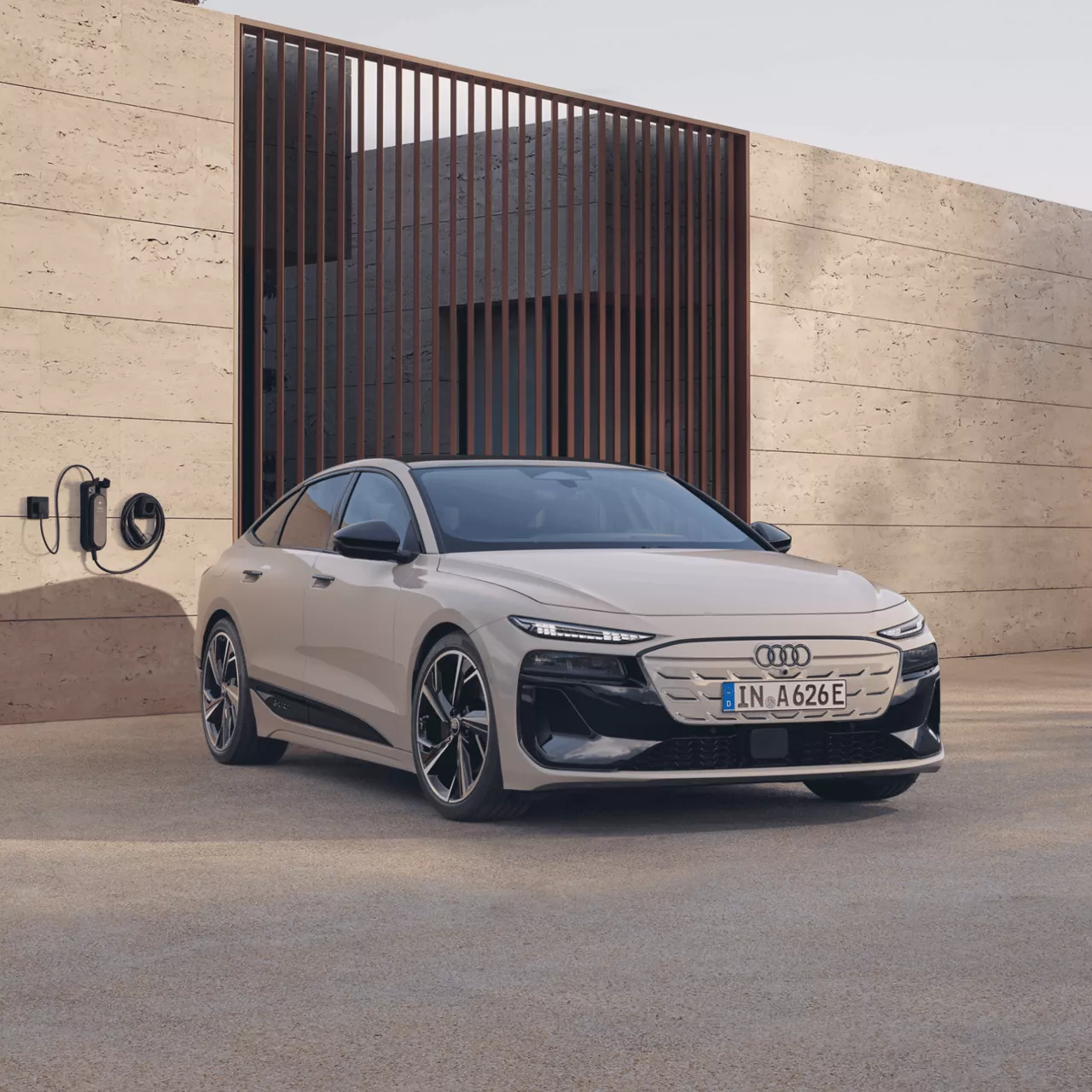 Electric Audi sedan parked by a charger on a modern driveway.