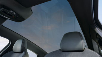 Interior view of a car with a focus on the panoramic sunroof, headrest, and car controls.