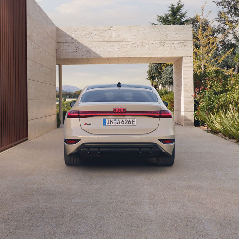 White Audi A6 Sportback e-tron performance with electric designation parked in a modern driveway.