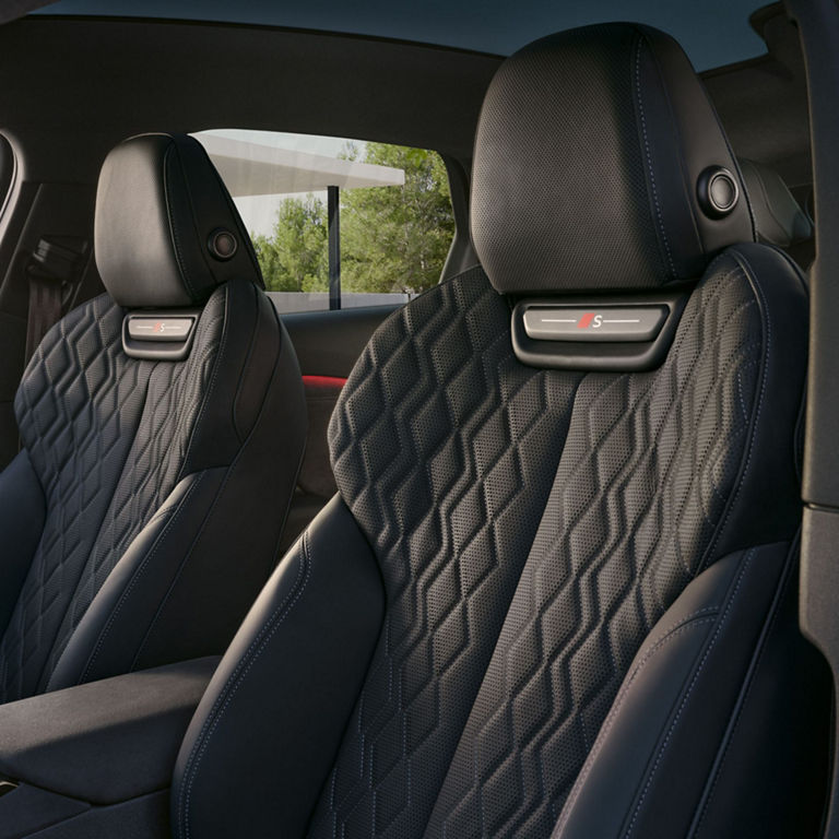 Car interior with black quilted leather seats and view through the rear window.