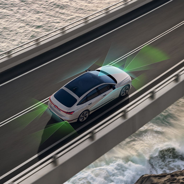 A white car with advanced sensor visualization driving over a bridge above the sea.