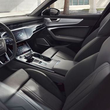Car interior with sleek dashboard, display screens, and leather seats.