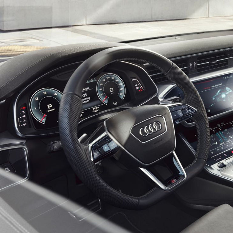 Interior view of an Audi car showcasing the steering wheel, dashboard, and multimedia system.