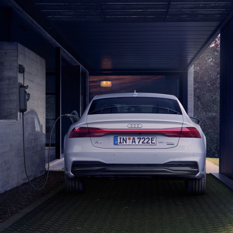 Car charging at an electric vehicle station in a modern carport.