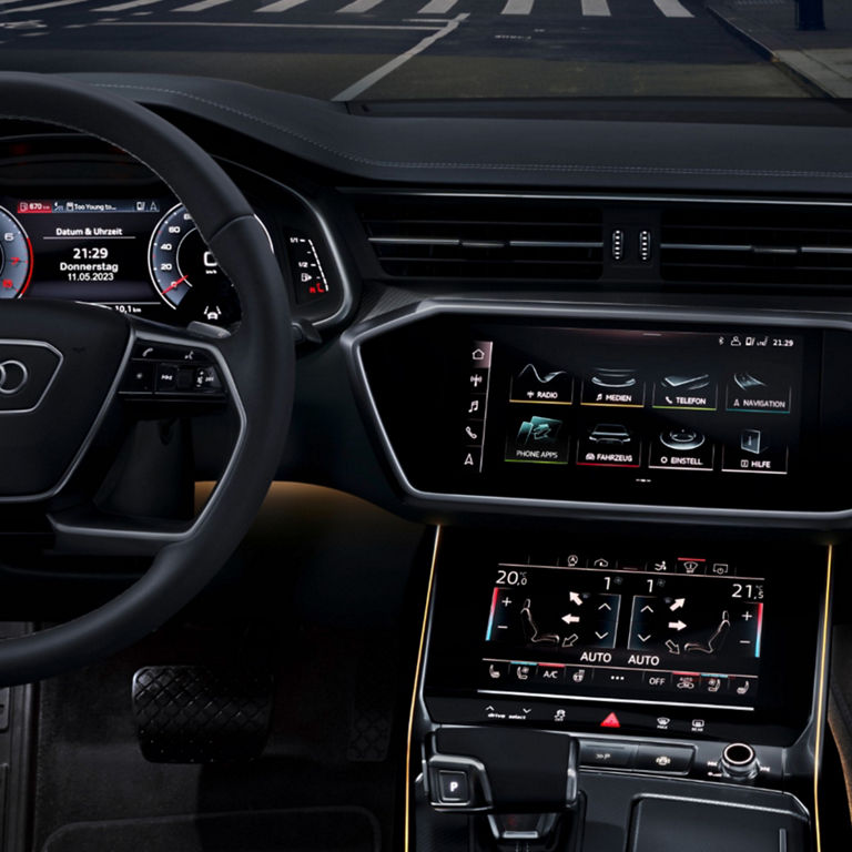 Interior view of an Audi vehicle's steering wheel and dashboard with digital displays.