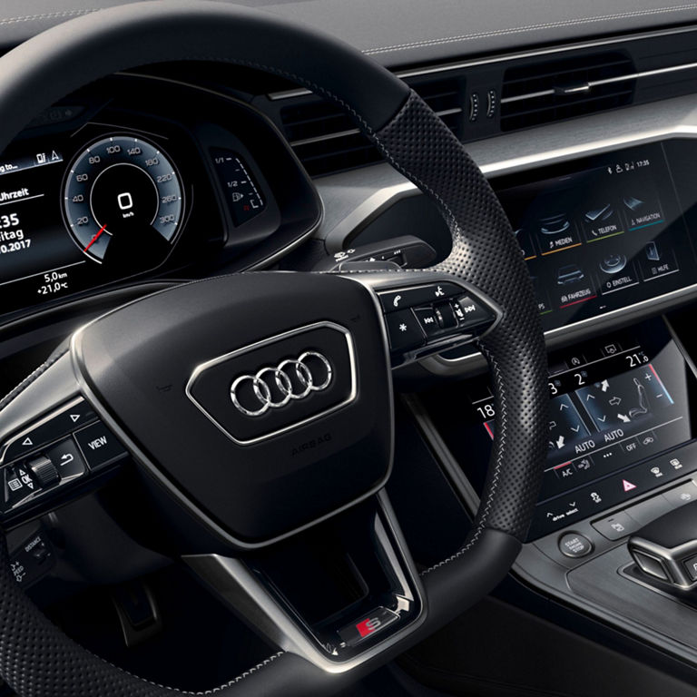 Interior view of an Audi car showing the steering wheel and digital dashboard display.