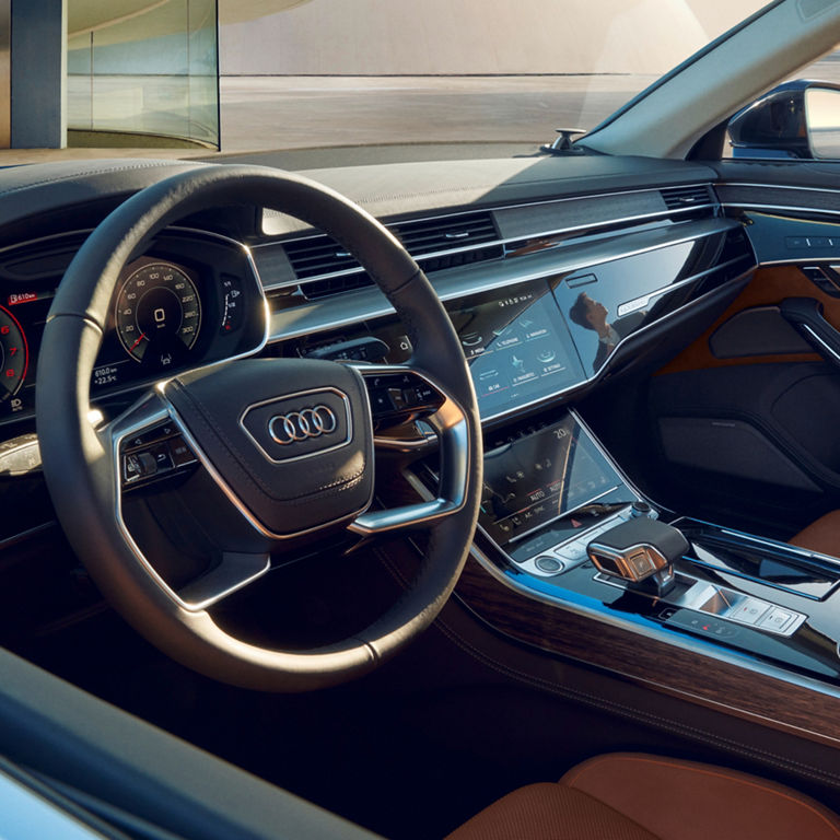 Interior view of an Audi car with a digital dashboard and leather seats.