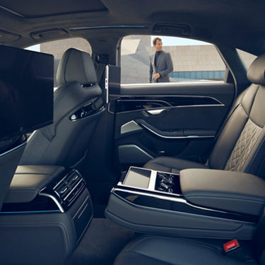 Car interior with leather seats and rear entertainment screens.