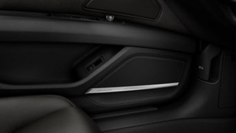 Close-up of a car's interior door panel with Bang & Olufsen speaker system.