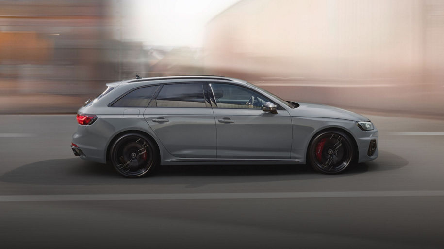 A grey car in motion on an urban road, with blurred background.