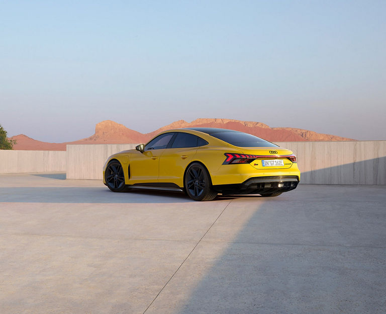  Yellow Audi car parked with desert hills in the background.