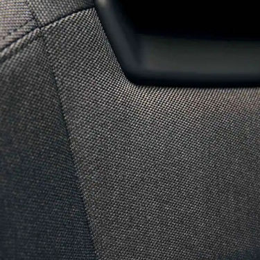 Close-up of textured fabric with a partial view of a black object.