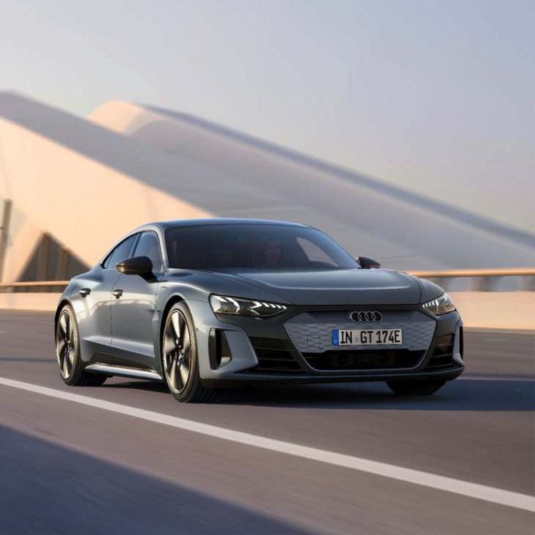 A grey Audi e-tron GT driving on a highway with motion blur.