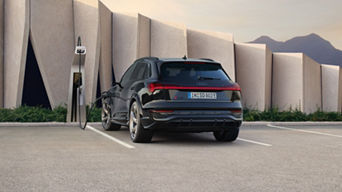 A parked Audi electric vehicle on charge beside a public charger