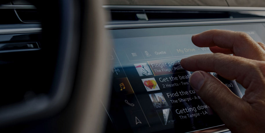 A person interacting with car's touchscreen display with various menu options.