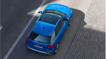 Aerial view of a blue suv driving on a road.