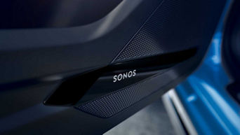 Close-up of a car door speaker grille with the 'SONOS' brand logo.