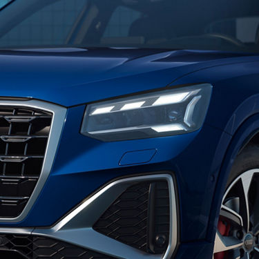 Close-up of a blue car's headlight and grille design.