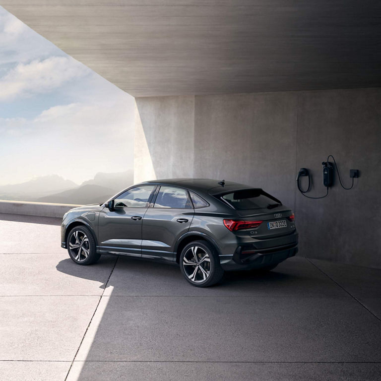 Rear view of Audi Q3 on the roof near a charging point. 