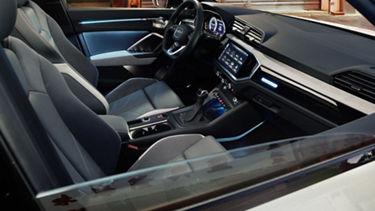 Interior view of Audi Q3 through an open passenger window.