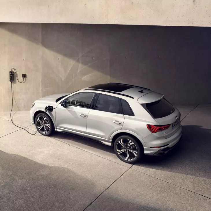 Ariel view of Audi Q3 tfsi e charging in solitary concrete basement.