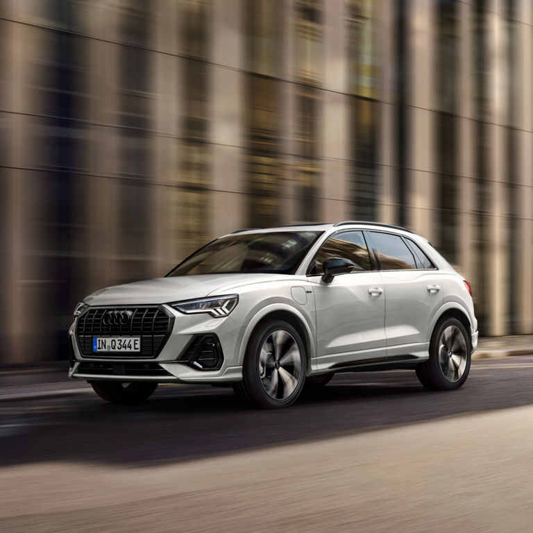 Front perspective view of Audi Q3 TFSI e in motion along the road.