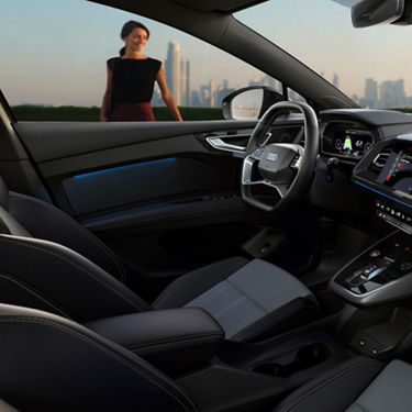 Interior of a car with leather seats and modern dashboard, city skyline in the background.