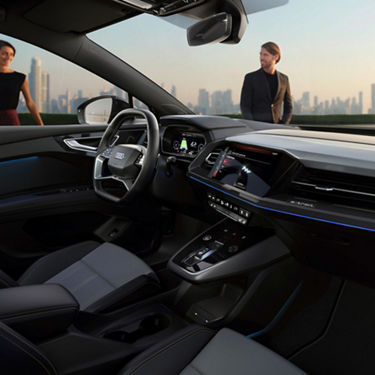 Interior view from passenger side of cockpit  with man and lady outside against a city skyline background.