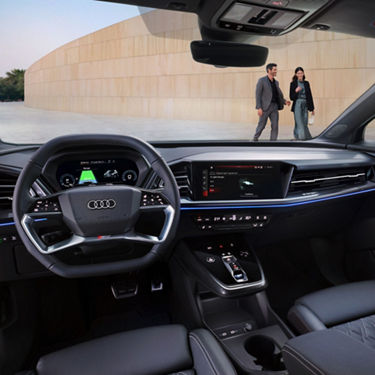 Interior view of an Audi car with leather seats, steering wheel, and dashboard displays.