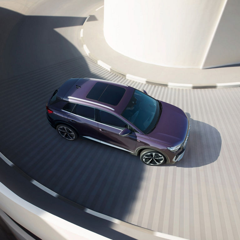 Ariel view of Audi Q4 e-tron travelling around a corner into a car park.