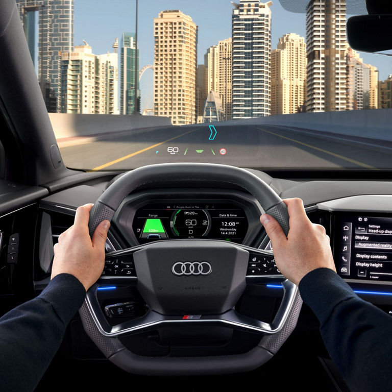 Driver's view inside a car with hands on the steering wheel and a digital dashboard.