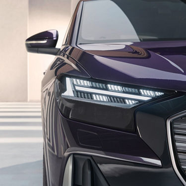 Close-up of a car's front headlight and grille in purple.
