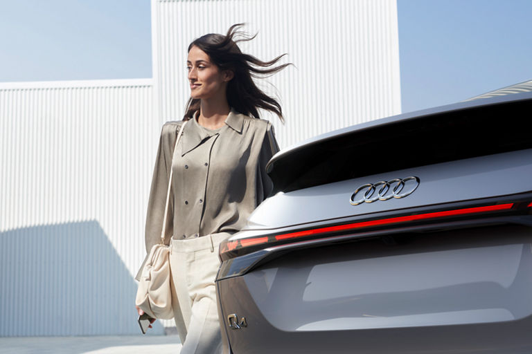 Person standing next to the trunk of an Audi Q4 e-tron.