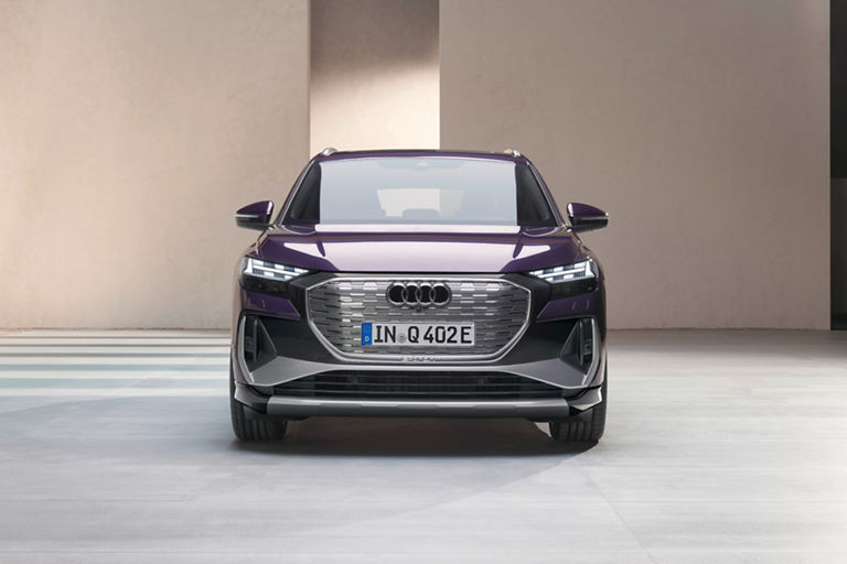 A purple Audi electric SUV parked in front of a neutral backdrop.