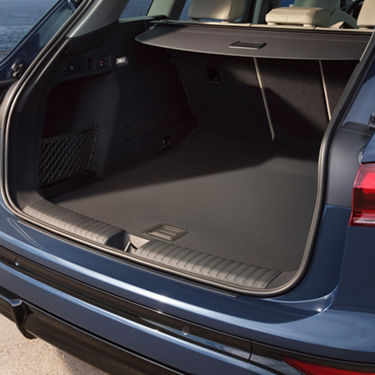 Empty trunk of a blue car with a privacy shelf and a net on the left side.
