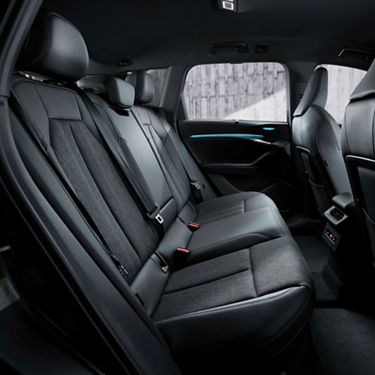 Interior view of a car's back seats with black upholstery.