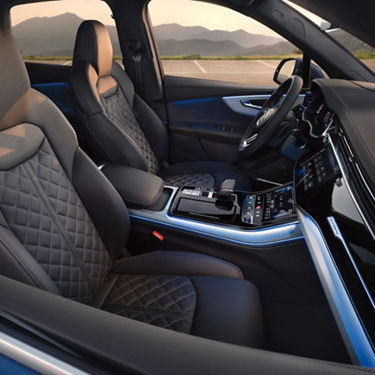 Interior view of a car with black leather seats and dashboard with touchscreen.
