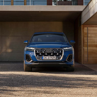 Blue Audi SUV parked in front of a modern building.