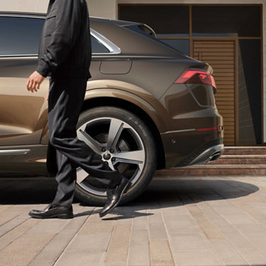 Side view of rear Audi Q8 tfsi e with a man walking passed.