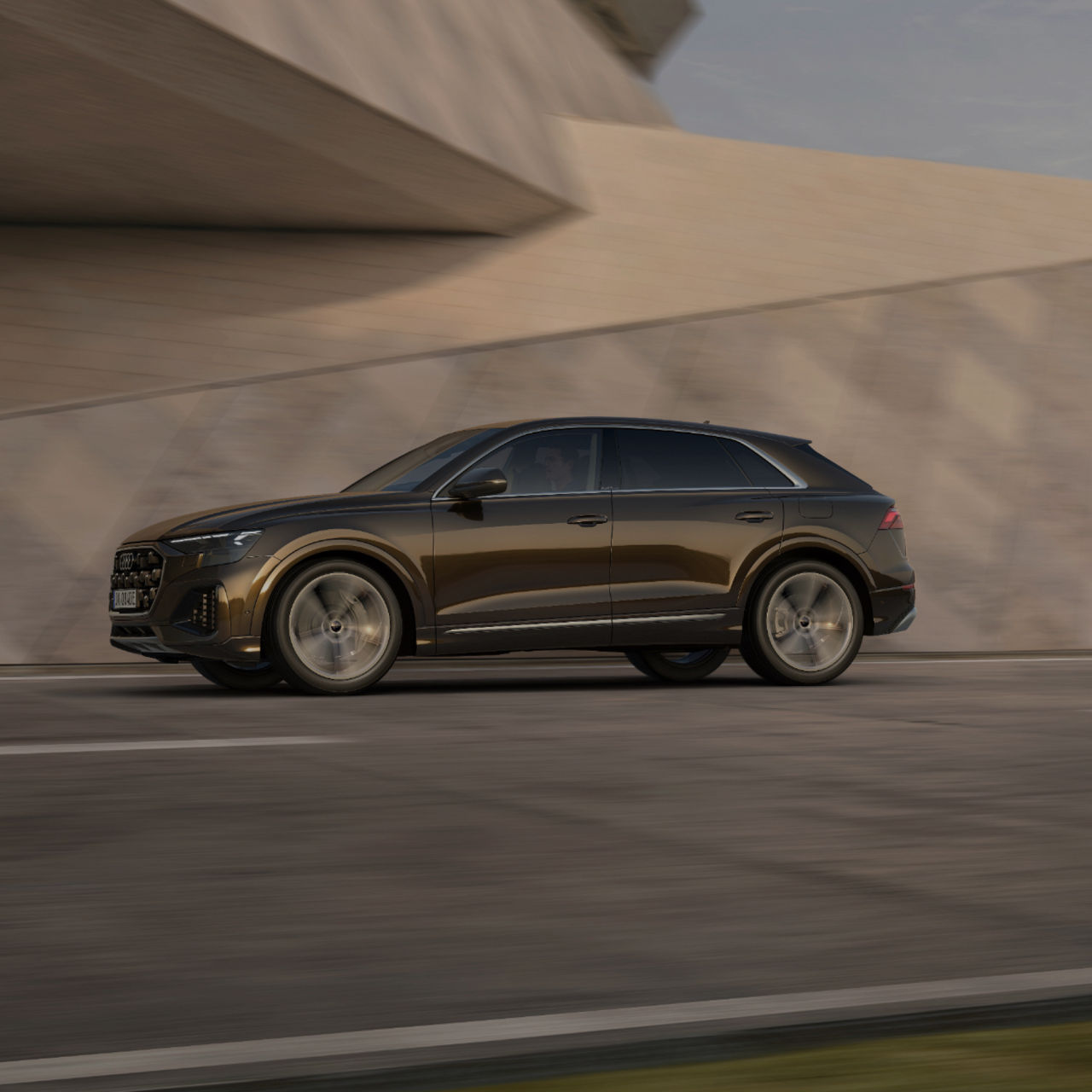 Audi Q8 TFSI e in motion on tarmac against modern architecture 