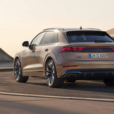  Audi Q8 parked on tarmac facing away. infront of modern architecture.