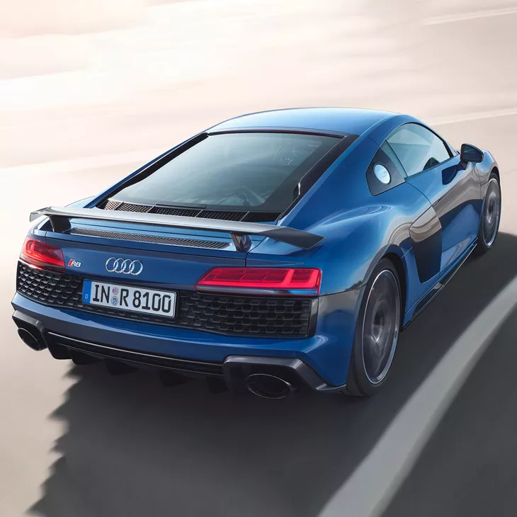 A blue car in motion with a blurred background.