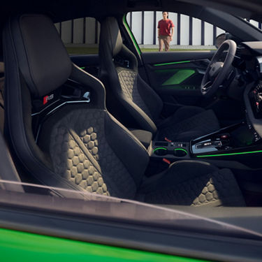  Audi RS3 Sportback car interior with black sport seats, green accents, and modern dashboard.