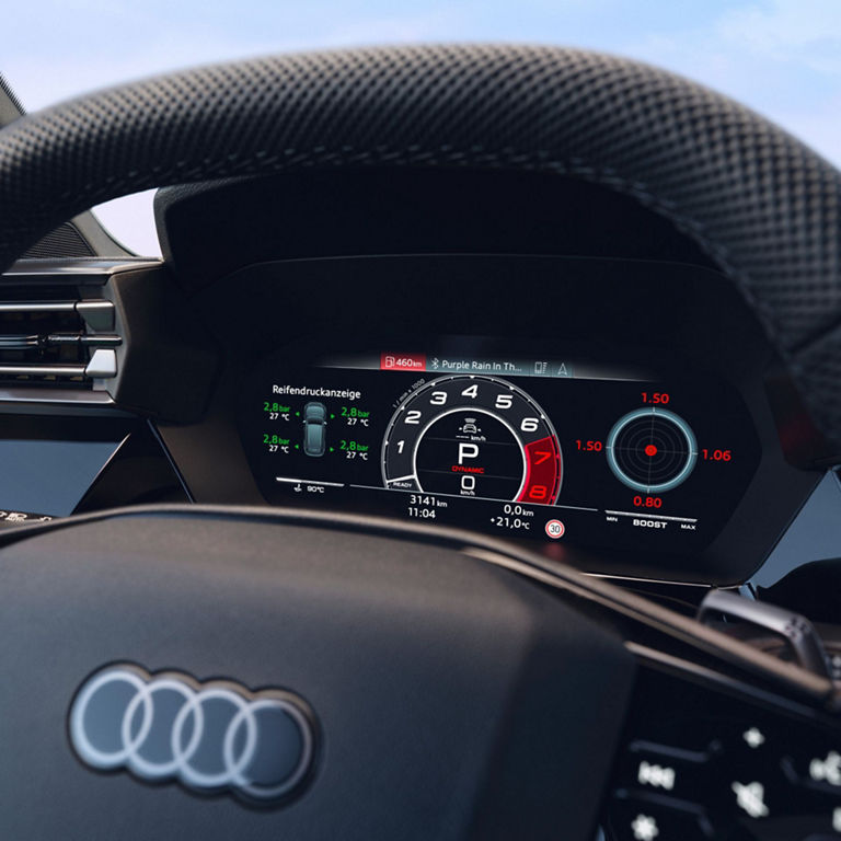 Audi RS3 Sportback car dashboard and steering wheel displaying digital gauges and infotainment screen.