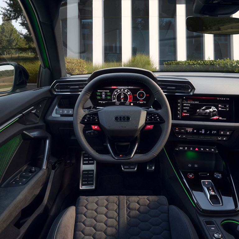 Interior view of aAudi RS3 Sportback car with a digital dashboard, steering wheel, and center console.